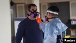 在美国德克萨斯州圣安东尼奥的东南护理康复中心疗养院,身穿防护服的急救人员正在为自己消毒,那里的许多居民和员工都感染了冠状病毒病。(2020年4月4日)