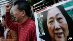 抗议人士在中国中央政府驻香港联络处外举行集会手举高瑜照片要求释放高瑜。著名媒体人高瑜曾经被电视认罪.(2015年11月27日)