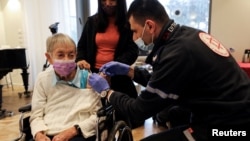 资料照片:90岁的丽莉·佐哈里在以色列内坦亚的一处退休之家接受第四剂新冠疫苗。(2022年1月5日)