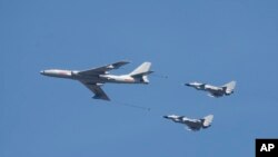 资料照片:中国空军一架轰-6轰炸机和两架歼-10战斗机在北京参加庆祝抗战胜利70周年纪念活动。(2015年9月3日)