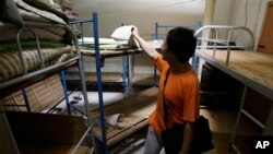 Nhà hoạt động nhân quyền Liu Dejun nhìn qua một căn phòng trong một 'nhà tù đen' ở Bắc Kinh.