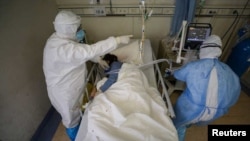 中国湖北武汉市红十字会医院内的医疗人员正在照顾一名新冠病毒肺炎患者。(资料照片)