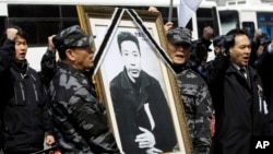 2010年3月26日,前韩国陆军司令情报特遣队士兵举着独立斗士安重根的遗像在他被日本处死一百周年之际在日本驻首尔大使馆前示威。