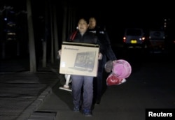 北京的外来务工人员手里提着有限的个人物品被连夜赶出他们在北京通州六环外的住所。(2017年11月23日)