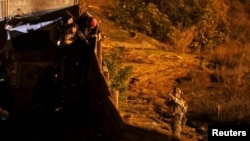 美国海关和边境保护局的一名执法人员将武器对准一名试图从墨西哥蒂华纳非法进入美国的移民。(2019年1月1日)