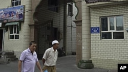 维吾尔族人走过中国新疆维吾尔族自治区乌鲁木齐市的一座穆斯林清真寺。(资料照片)