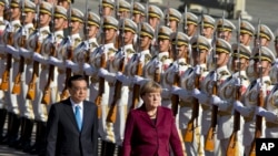 中国国务院总理李克强和德国总理默克尔在北京人民大会堂外的欢迎仪式上。(2015年10月29日)