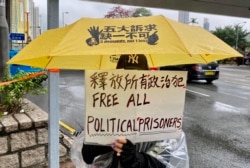 声援47名香港民主派人士的市民手持标语 (美国之音/汤惠芸)