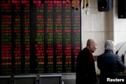 2019年1月18日,在北京一家经纪公司,投资者在显示股票价格的电子板附近聊天。由于北京与华盛顿的关税战谈判可能取得进展,中国股市在这一天上涨。