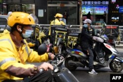 美团快递的快递员们正准备把一家北京餐馆的午餐饭盒送出。(2021年4月27日)