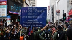 资料照:香港警察对在中国国庆日要求北京政府释放12港人的抗议者展示警示牌。(2020年10月1日)