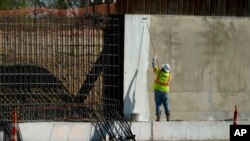 资料照片:一名建筑工人为德克萨斯州米逊的一段边界墙涂漆。(2020年11月16日)