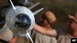 俄罗斯的军事团队检查其飞机所链接的导弹。(2015年10月6日)