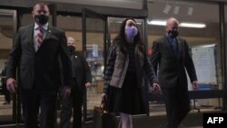 资料照片:华为公司高管孟晚舟和她的保安团队走出加拿大不列颠哥伦比亚省最高法院。 （2020年12月8日）