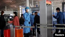 医护人员在检测进入北京机场的旅客的体温。(2020年11月5日)