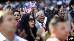 Alfonso Perez, of the Dominican Republic, cheers at the start of a naturalization ceremony for 755 new United States citizens at Turner Field, home of the Atlanta Braves baseball team in Atlanta, Sept. 16, 2016.