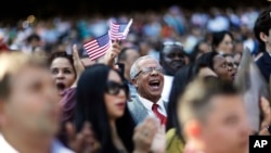 归化美国的新公民宣誓入籍(资料图)。有些人是通过公司雇用,然后由公司出面申请允许工作的H1B签证,经过数年工作后申请绿卡,最后达到移民美国的目的。