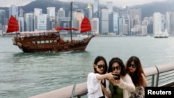 资料照:游客在香港尖沙咀的维多利亚湾前拍照留影。(2024年4月29日)