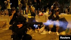 在香港抗议者冲入立法会后,一名香港警察在立法会外向示威者发射催泪弹。(2019年7月1日)