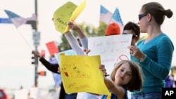 六岁的女孩伊兹和母亲一道加入示威人群,抗议科罗拉多州杰斐逊郡校董会审议历史教纲的计划。(2014年10月4日)
