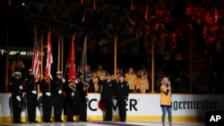 凯利·安德伍在NHL冰球季后赛第二轮纳什维尔掠夺者队对温尼伯喷气机队的第二场比赛前演唱国歌。(2018年4月30日)