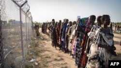 FILE - Women from the Murle ethnic group wait in a line for a food distribution by the United Nations World Food Program (WFP) in Gumuruk, South Sudan, June 10, 2021.