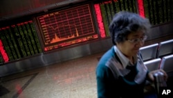 北京一位股民在证券交易公司里,身后是显示股票行情的电子屏幕(2016年1月4日)