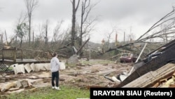 资料照片:阿拉巴马州一名男子正在查看龙卷风造成的损失(2021年3月25日)