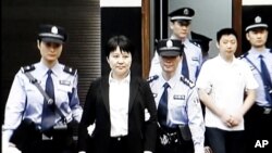 中央电视台画面显示薄熙来妻子谷开来(中间站立者)2012年8月9日在中国东部的合肥市中级人民法院出庭受审(2012年8月9日)