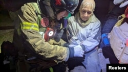 乌克兰国家紧急服务局在第聂伯罗彼得罗夫斯克州的新闻社发布的照片显示,在克里维里赫一处俄罗斯导弹袭击现场,救援人员治疗一名受伤的居民。(2025年3月14日)