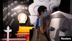 香港支联会负责运营的六四纪念馆内,一名游客在一块刻有民主女神像的画板旁祈祷。(2021年5月30日)