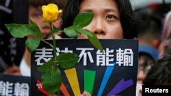 在台湾立法院就同性婚姻法案表决之际,同性婚姻支持者举着玫瑰花悼念那些因受歧视而自杀的人。(2019年5月17日)