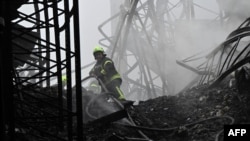 Український рятувальник працює на місці обстрілу безпілотником будівлі складу в Бориспільському районі Київської області 20 грудня 2024 р. Genya SAVILOV/AFP