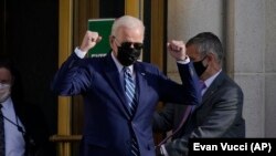 在首都华盛顿郊外的马里兰州贝塞斯达市,美国总统拜登在完成例行体检结束后走出沃尔特·里德国家军事医疗中心时做着手势。( 2021年11月19日)