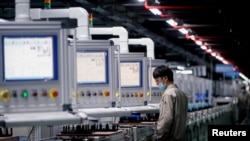 中国安徽合肥一家生产电动汽车电池的工厂工人在生产线上。(2021年3月30日)