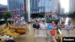 水淹武汉,人们利用挖土机前去上班(2016年7月8日)