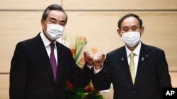 日本首相菅义伟在东京会晤到访的中国外长王毅。(2020年11月25日)