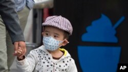 2016年10月14日,北京一名儿童戴口罩。北京市空气重污染应急指挥部办公室在下午将蓝色预警提升至黄色预警,北京城区PM2.5浓度接近每立方米350微克,达到6级严重污染