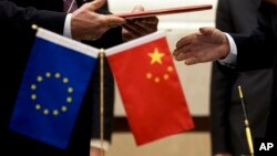 资料照片:欧盟旗帜与中国国旗。