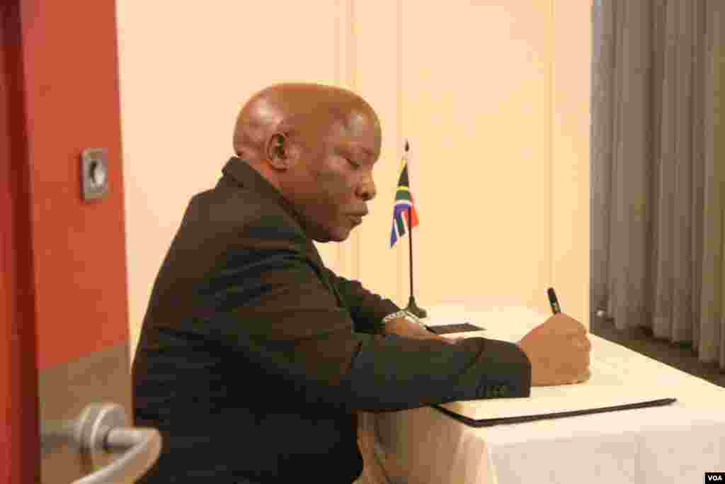 大使兰加在吊唁簿上写下吊唁词(美国之音东方拍摄)