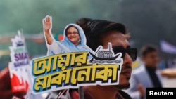 民众2024年1月4日手持支持现任总理谢赫·哈西娜(Sheikh Hasina)的宣传牌。(路透社)