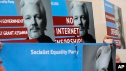 抗议者挥舞着阿桑奇的海报,在伦敦威斯敏斯特地方法院门口示威。(2019年5月2日)