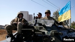 9月5日在南部港口城市马利乌波尔的一个检查哨卡,乌克兰军人坐在一辆装甲运兵车上。