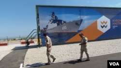 哈萨克斯坦同中国和俄罗斯到保持很好关系。2015年俄罗斯在里海岸边举行的一次军事比赛活动上,两名哈萨克军官走过。中国也参加了那次比赛。(美国之音白桦拍摄)