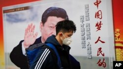 资料照:一名男子走过北京街头中国领导人习近平的宣传画。
