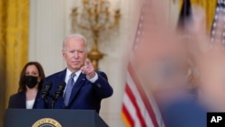 美国总统拜登在白宫就获得两党支持的基础设施法案发表讲话后,在回答媒体提问时做手势。副总统哈里斯在一旁聆听。(2021年8月10日)