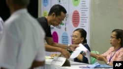 一名缅甸选民在仰光一个投票站里为议会差额选举投票。(2018年11月3日)