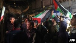 Warga Palestina merayakan berita kesepakatan gencatan senjata antara Israel-Hamas, di sepanjang jalan di Deir el-Balah, Jalur Gaza tengah, pada tanggal 15 Januari 2025.