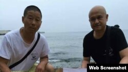 姜建军(左)、王承刚在大连老虎滩海边祭奠两天前海葬于附近海域的刘晓波。(2017年7月17日 推特图片)