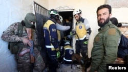 叙利亚民防组织成员(被称为“白头盔”)于2024年12月9日在赛德纳亚监狱,在反叛武装人员簇拥中搜寻在那里的囚徒。